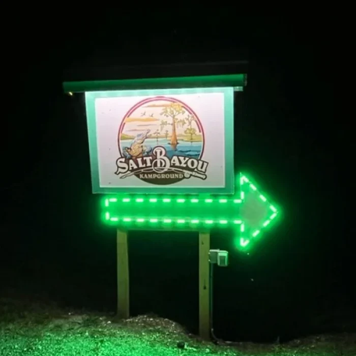 The sign for Salt Bayou Kampground RV Park at night